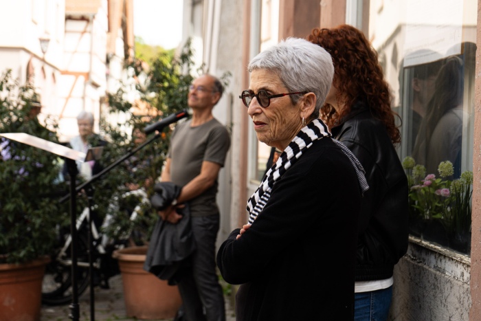 Frau steht vor Haus