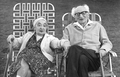 Älteres paar sitzt im Garten. Sie hält seine Hand